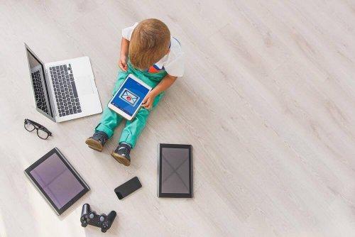 इलेक्ट्रॉनिक डिवाइस से खेलता हुआ बच्चा